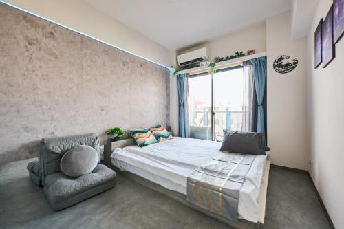a bedroom with a bed and a chair and a window at Cyber Shinjyuku Tokyo Room in Tokyo