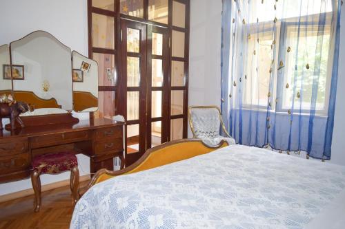 a bedroom with a bed and a desk and a mirror at Guesthouse Harašić in Split