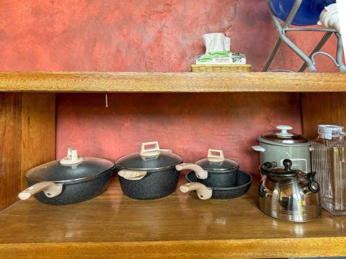 a shelf with four pots and pans on it at Kismet House Central & Private Cozy Home in General Luna in General Luna