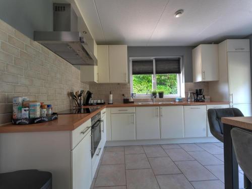 a kitchen with white cabinets and a sink at Villa in Zeewolde near Horsterwold Forest in Zeewolde