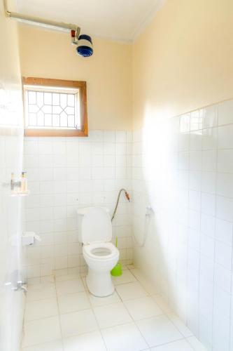 a bathroom with a toilet and a window at Arusha backpackers homes in Arusha