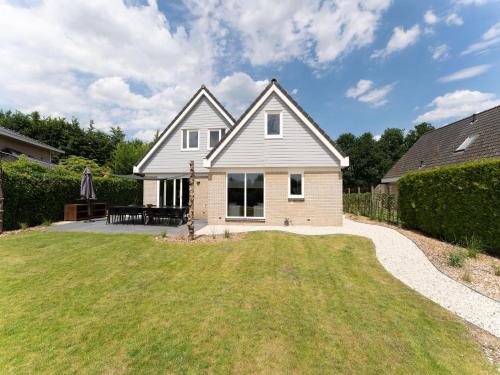 a white house with a lawn in front of it at Villa in Zeewolde near Horsterwold Forest in Zeewolde