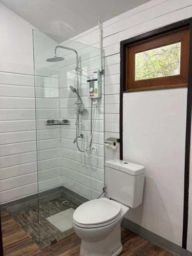 ein Badezimmer mit Toilette und Glasdusche in der Unterkunft Ban Tha Ton Do Koh Yao noi in Ko Yao Noi