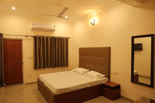 a small bedroom with a bed and a mirror at Hotel Times Stay in Udaipur