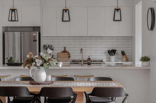 a kitchen with a table with chairs and a refrigerator at Luxury On Lakeside in Mount Beauty