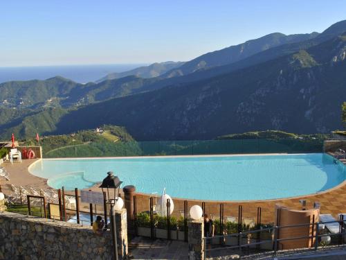 a large swimming pool with mountains in the background at Apartment Finale Ligure near Ondina Beach in Magliolo