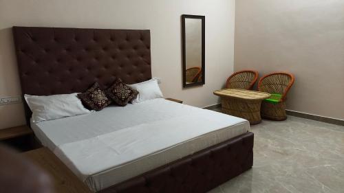 a bedroom with a large bed and two chairs at Hotel Times Stay in Udaipur