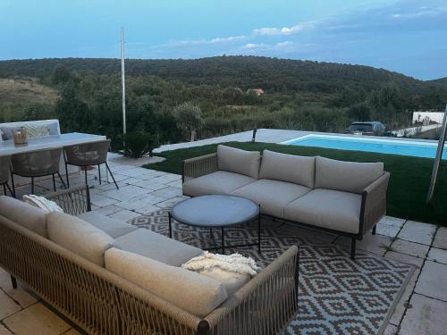 a patio with couches and a table and a pool at Villa Lavender in Felsőörs