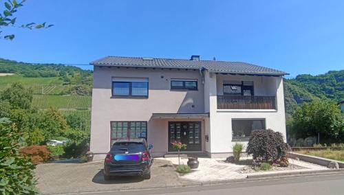 a car parked in front of a house at Ferienwohnung mit Blick auf die Moselloreley in Piesport