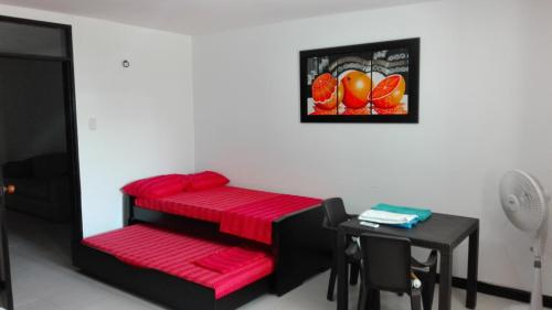 een kamer met een tafel en een rode plank bij Playa Los Cocos in Santa Marta