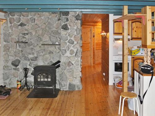 a living room with a stone wall with a stove at 11 person holiday home in Edland in Vågsli