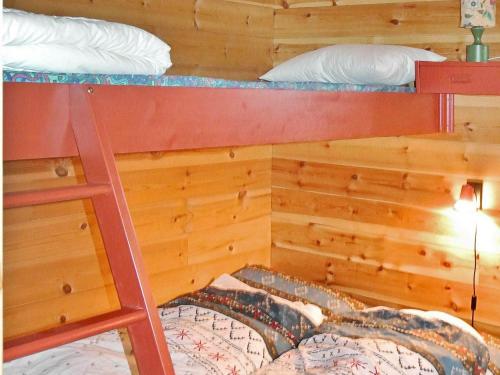 a bedroom with two bunk beds and a ladder at 11 person holiday home in Edland in Vågsli