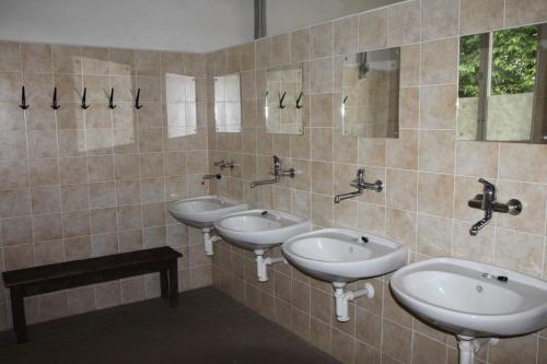 a bathroom with three sinks and two mirrors at Penzion Haberský vrch in Habří