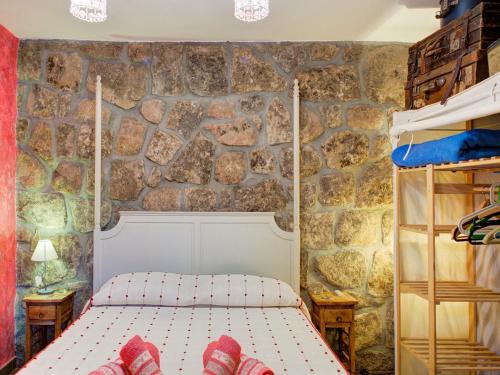 a bedroom with a bed and a stone wall at Flat in Galapagar with Spa and Mountain Views in Galapagar
