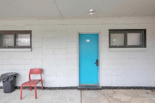 a red chair and a blue door on a building at Private Getaway for 2 • Near Dining Entertainment in Woodhaven