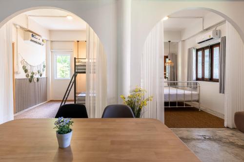 a dining room with a table and a bedroom at Baan Old Town Boutique Stay, Phuket Town in Phuket