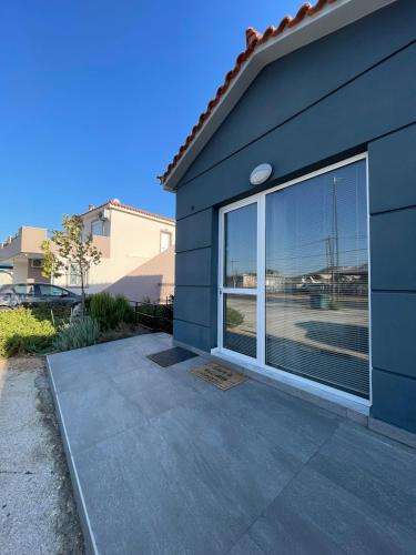 a blue house with a large glass window at RunWay Stay-24h self check in- Athens Airport in Porto Rafti