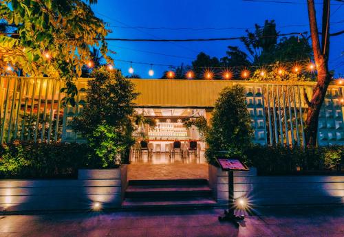 a courtyard with trees and lights in a building at Angkor Land House in Phumĭ Réach Born