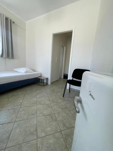 a room with a bed and a refrigerator in it at RunWay Stay-24h self check in- Athens Airport in Porto Rafti