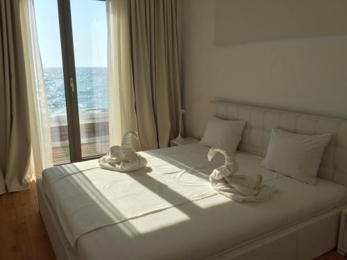 a bed with towels on it in a room with a window at Villa Cape Vergoti in Lozenets