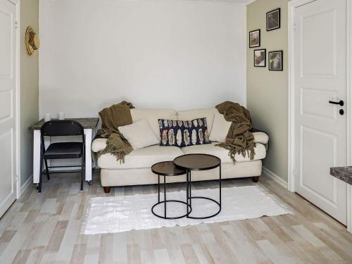 a living room with a couch and a stool at Serene Seaside Retreat in Adelso-By Traum in Adelsö