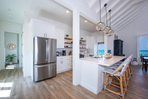 a kitchen with a stainless steel refrigerator and white cabinets at Azure home in Palmetto Point