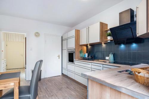 a kitchen with white cabinets and a wooden table at Ferienwohnung Deister Blick in Rodenberg