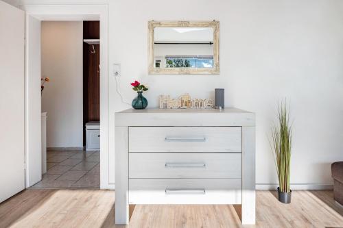 a white dresser in a living room with a mirror at Ferienwohnung Deister Blick in Rodenberg