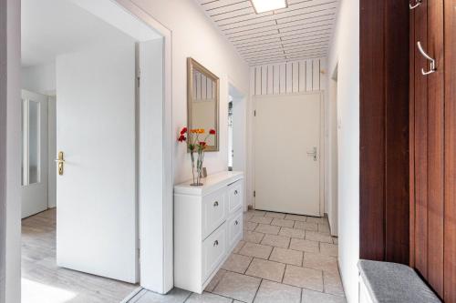 a hallway with a vase of flowers on a dresser at Ferienwohnung Deister Blick in Rodenberg