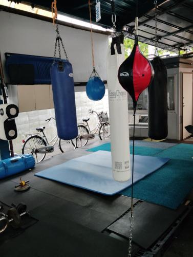 a gym with two blue boxing bags and some bikes at Barrier Free Guesthouse Support Included in Osaka
