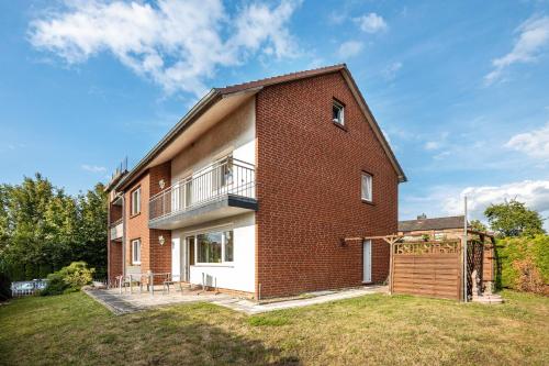 a brick house with a balcony and a yard at Ferienwohnung Deister Blick in Rodenberg