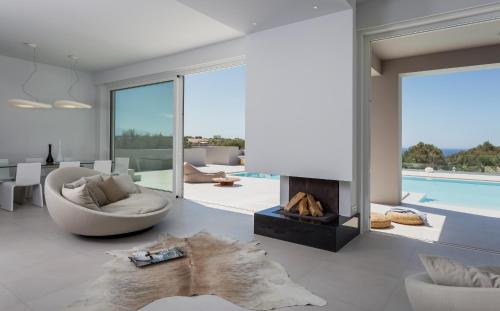 a living room with a fireplace and a couch at White Grace - A Seductive World of Luxury in Pigi
