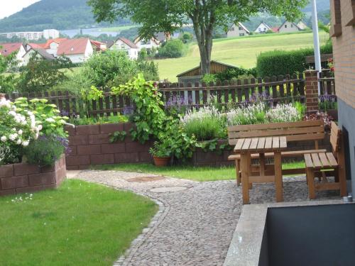 a wooden bench in a garden with a fence at Ferienwohnung Jena-Zoellnitz in Zöllnitz