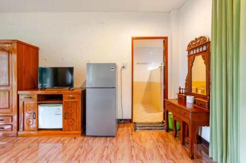 a kitchen with a refrigerator and a desk and a mirror at Green Heaven Bungalow 2 in Mae Nam