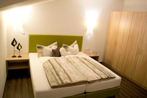 a bedroom with a bed with a green headboard at Appartement Tirol in Biberwier