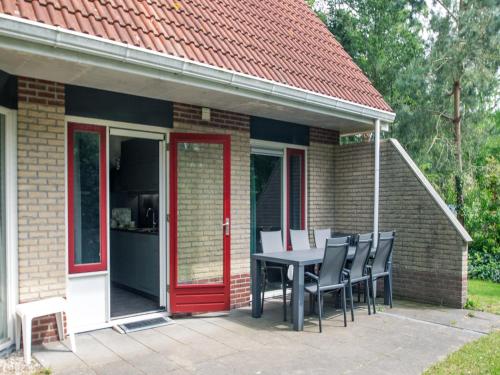 a house with a table and chairs on a patio at Holiday Home in Lemele near Nature Reserve in Lemele