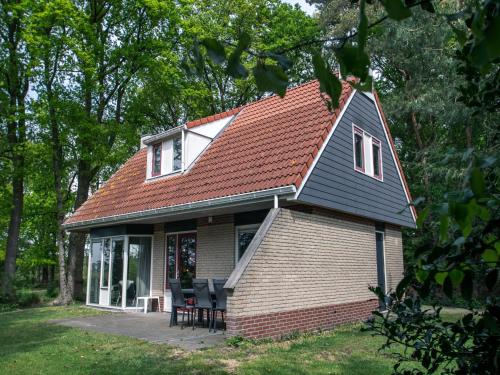 a small house with a red roof and chairs at Holiday Home in Lemele near Nature Reserve in Lemele