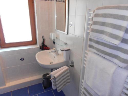 ein Bad mit einem Waschbecken und einem Spiegel in der Unterkunft Almblick Ferienwohnung in Balderschwang
