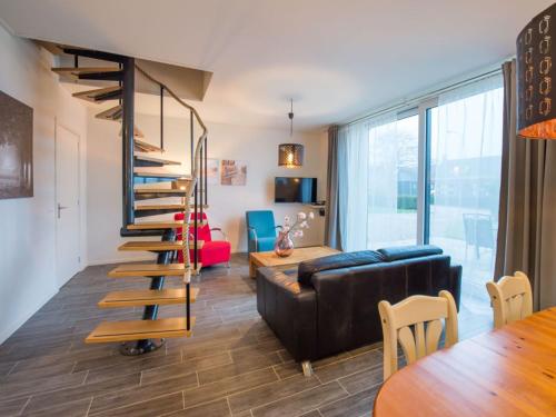 a living room with a spiral staircase and a couch at Holiday Home in Biggekerke near the Beach in Biggekerke