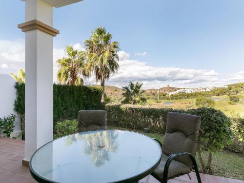 a glass table and chairs on a patio at Alhaurín Villa with Terrace in Alhaurín el Grande