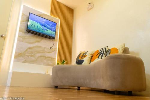 a living room with a couch and a flat screen tv at Seawind Condominium Near Airport in Davao City