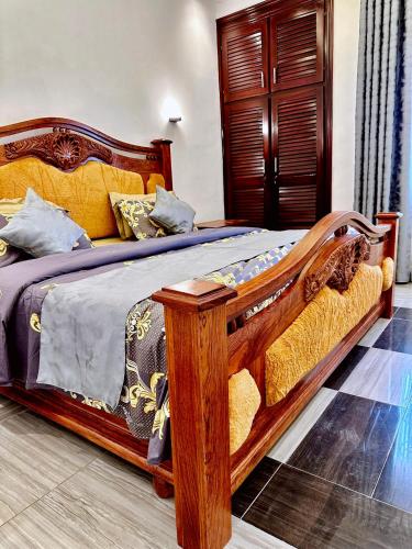 a bed with a wooden frame in a room at Résidence Prestige KGV in Douala