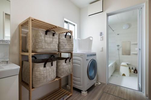 a laundry room with a washer and dryer at Fukuoka Airport 5 in Shime