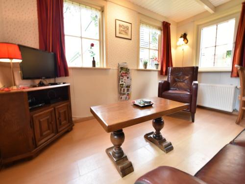 a living room with a table and a tv at Holiday home in with cycling area in Den Ham