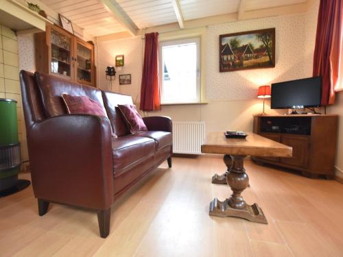 a living room with a leather couch and a table at Holiday home in with cycling area in Den Ham