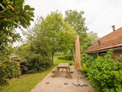 a wooden picnic table in a garden next to a building at Holiday home in with cycling area in Den Ham