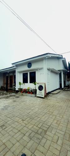 a white building with a sign in front of it at Griya Laksita Haven Dieng in Kejajar