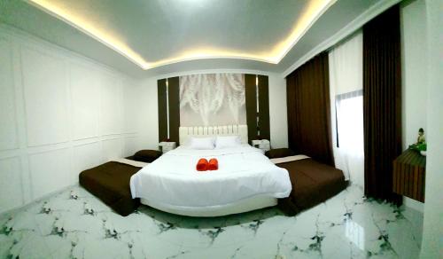 a bedroom with a large white bed with marble floors at Griya Laksita Haven Dieng in Kejajar