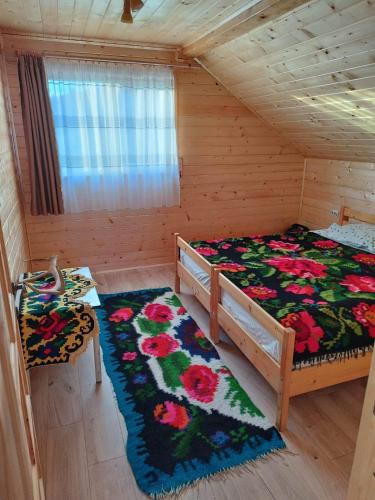 a bedroom with a bed in a wooden cabin at Casa MAN in Mărişel