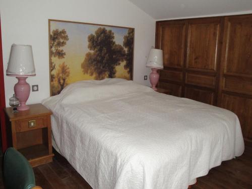 a bedroom with a white bed and two pink lamps at Nettancourt Family Stay in Revigny-sur-Ornain